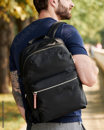 Man with a backpack on his shoulder close-up photo