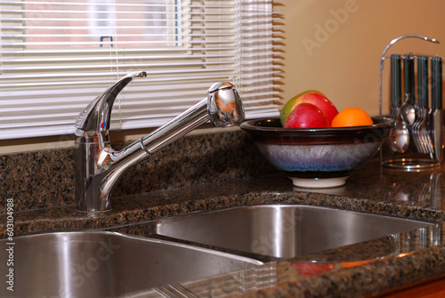 Interior of a modern kitchen with granite counter top and stanless steel double sink