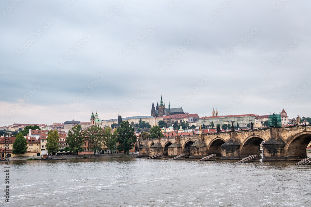 Castle of Prague and Saint Vitus Cathedral as seen from the shore of the Vltava river at dusk.