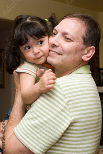 Adult man carrying and hugging little two year old daughter