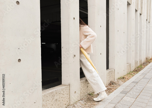 A woman holding umbrella walking into the gap in the wall photo