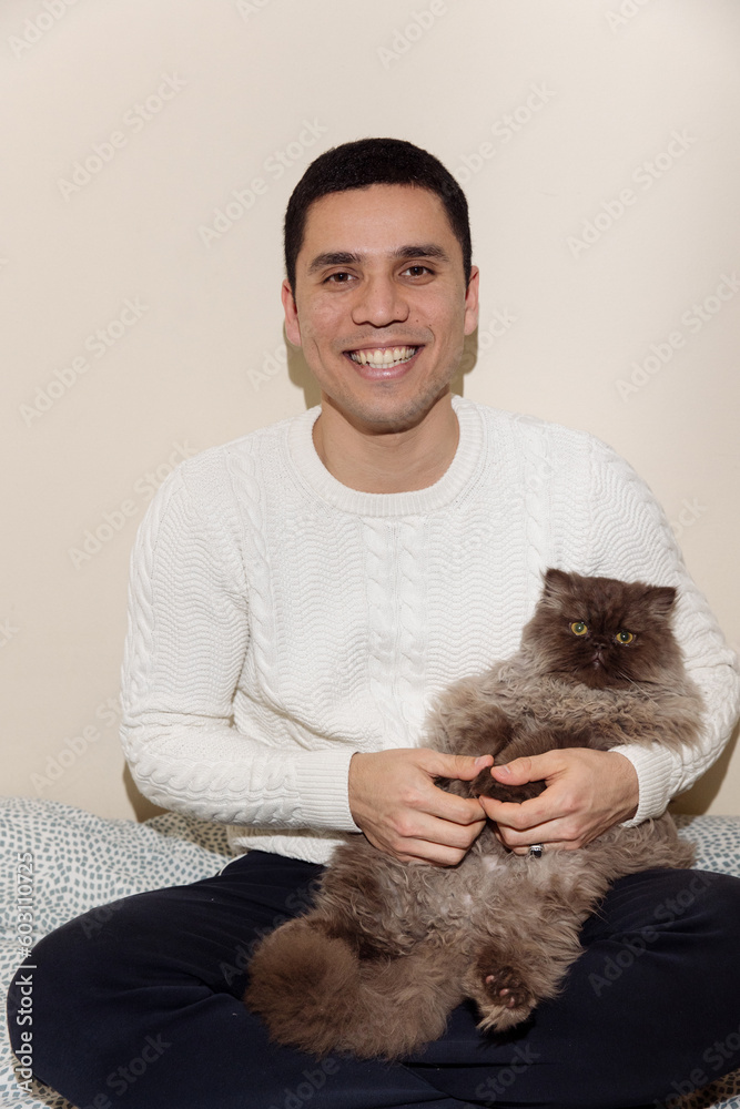 a man holds a fluffy cat in his arms a man holds a fluffy cat in his arms