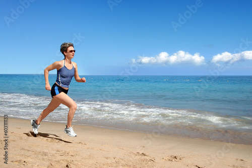 Young woman running alone on the beach