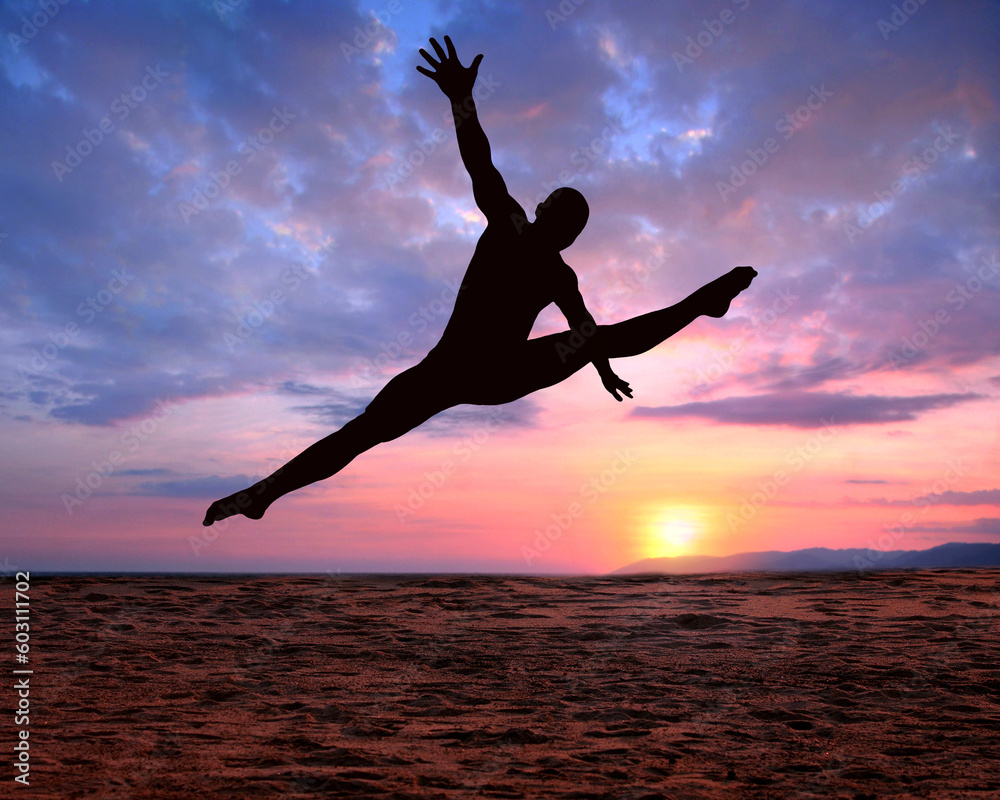 A silhouette of a jumping man on a colorful sunset background