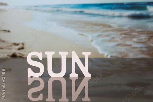 Sun lettering, with out-of-focus beach background, vacation concept