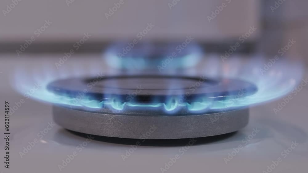 gas stove with fire, closeup side view of flame, natural gas at home
