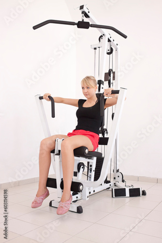 Obraz na plátně Young blond caucasian woman working out in gym