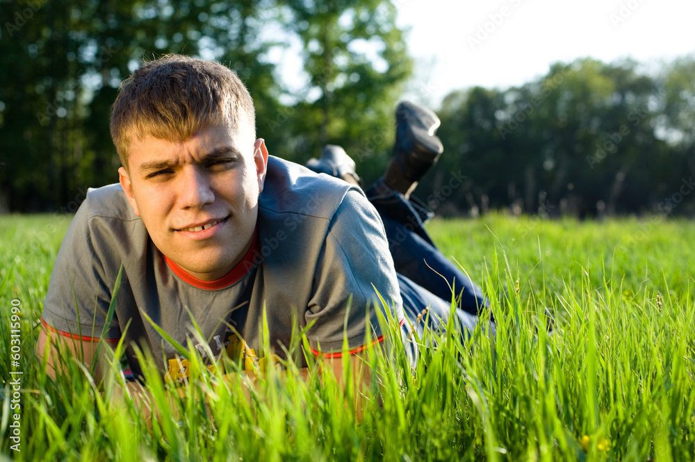 Fototapeta premium Young man lying down of grass. Copy space