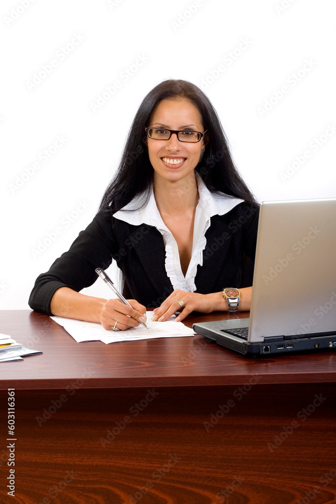 Young businesswoman working at her desk signing papers Young businesswoman working at her desk signing papers
