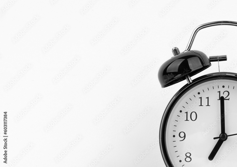 Black alarm clock on white wall background Black alarm clock on white wall background