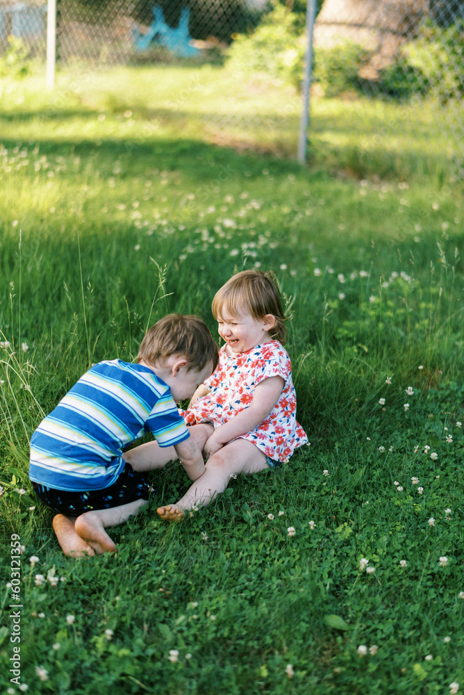 Happy Smiling toddler kids playing in backyard together in summer