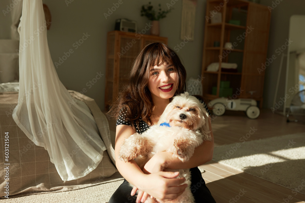 Happy good-looking brunette woman of 20s holding her chinese crested dog in hands, happy to return home, hugging her pet with joy, showing her love and affection. People and their domestic animals Happy good-looking brunette woman of 20s holding her chinese crested dog in hands, happy to return home, hugging her pet with joy, showing her love and affection. People and their domestic animals