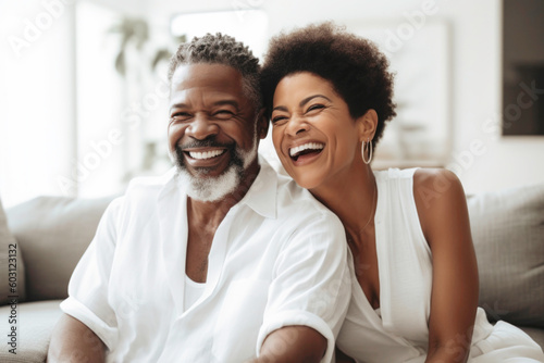 Portrait of happy mature successful Black couple laughing together at home.