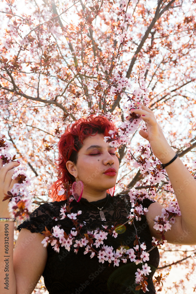 person between almond tree's branches in blossom with eyes closed person between almond tree's branches in blossom with eyes closed