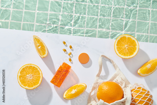 orange transparent vitamin bottle with citrus fruits and pills