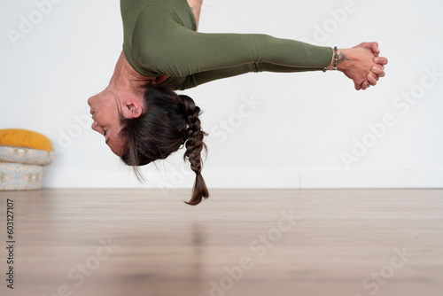 Woman performing aerial yoga pose in studio photo