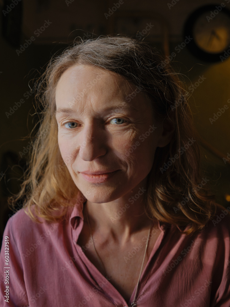 Mature smiling woman in dark room Mature smiling woman in dark room