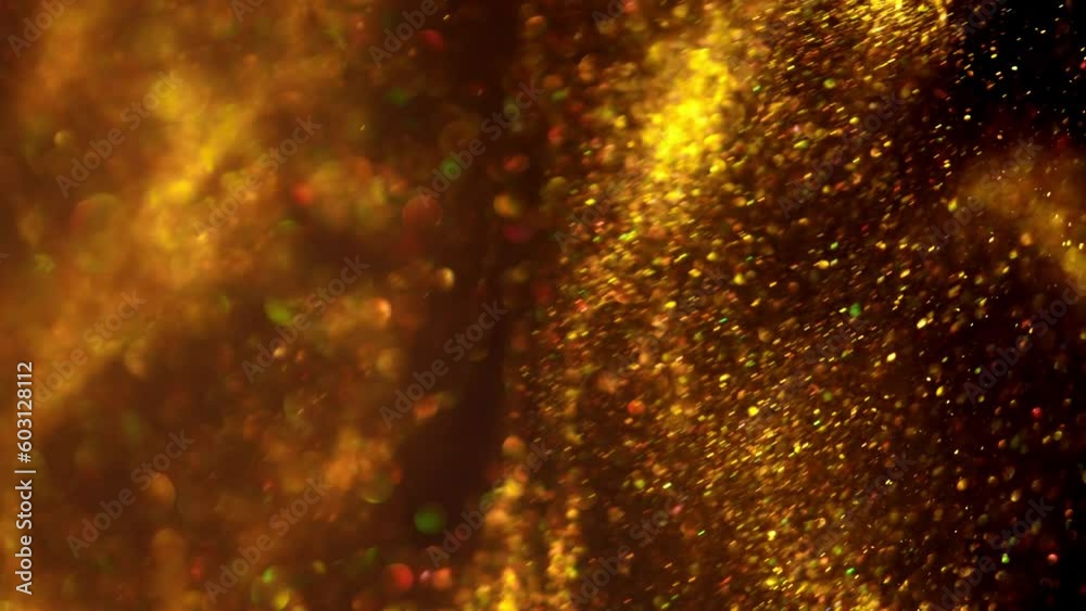 Golden glitter background in slow motion. Beautiful transition with real gold particles flying in wind on black background Golden glitter background in slow motion. Beautiful transition with real gold particles flying in wind on black background