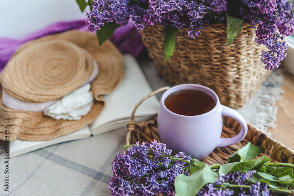Cup of tea, straw hat and lilac basket, spring still life