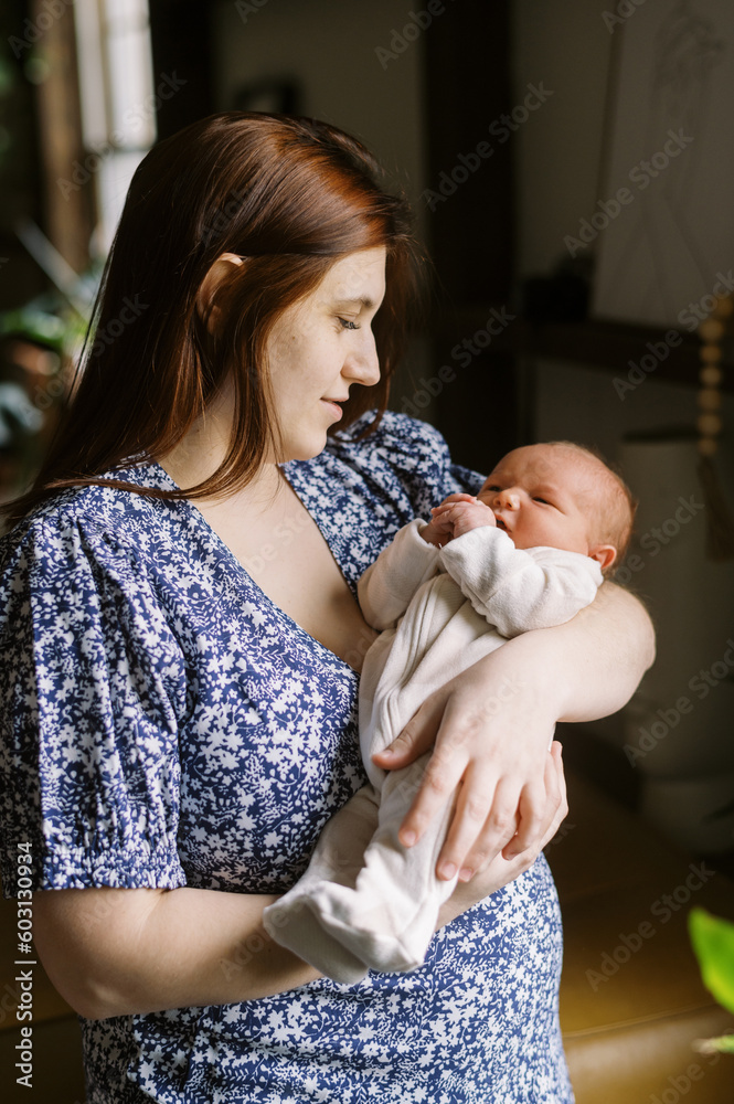 happy new mom holding her newborn baby in her arms at home happy new mom holding her newborn baby in her arms at home