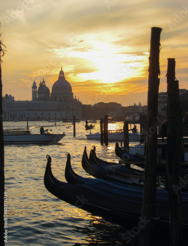 Venezia, Italia, vista del tramonto, sullo sfondo la basilica di Santa Maria della Salute dal molo di Piazza San Marco, con gondole e laguna in primo piano © Jacopo