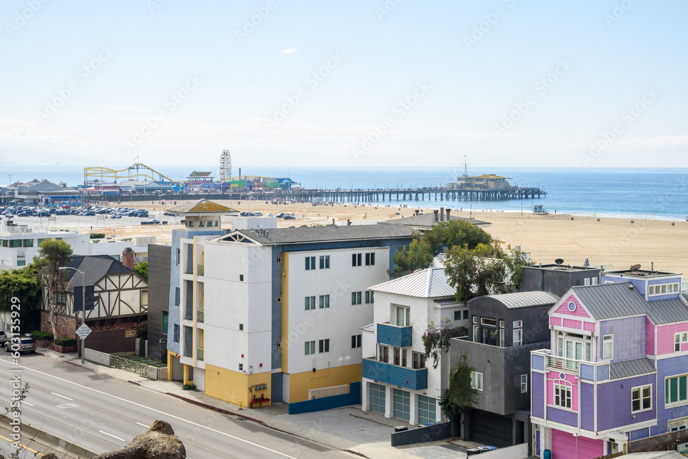 View of a Santa monica beach on a partly cloudy autumn morning. Colourful beachfront residential buildings are in foreground.