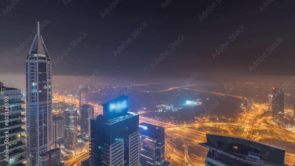 Obraz premium Aerial skyline with Golf Club, hotels and residential areas far away in desert in Dubai all night timelapse, UAE, top view