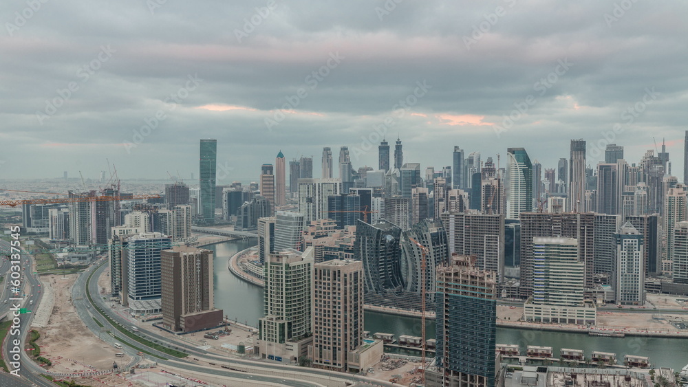 Skyline with modern architecture of Dubai business bay towers night to day timelapse. Aerial view