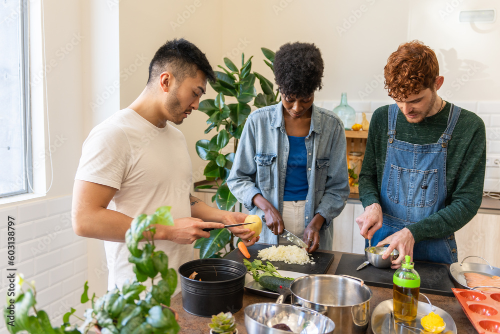 Three People Cooking Food Together In A Modern Kitchen. Three People Cooking Food Together In A Modern Kitchen.