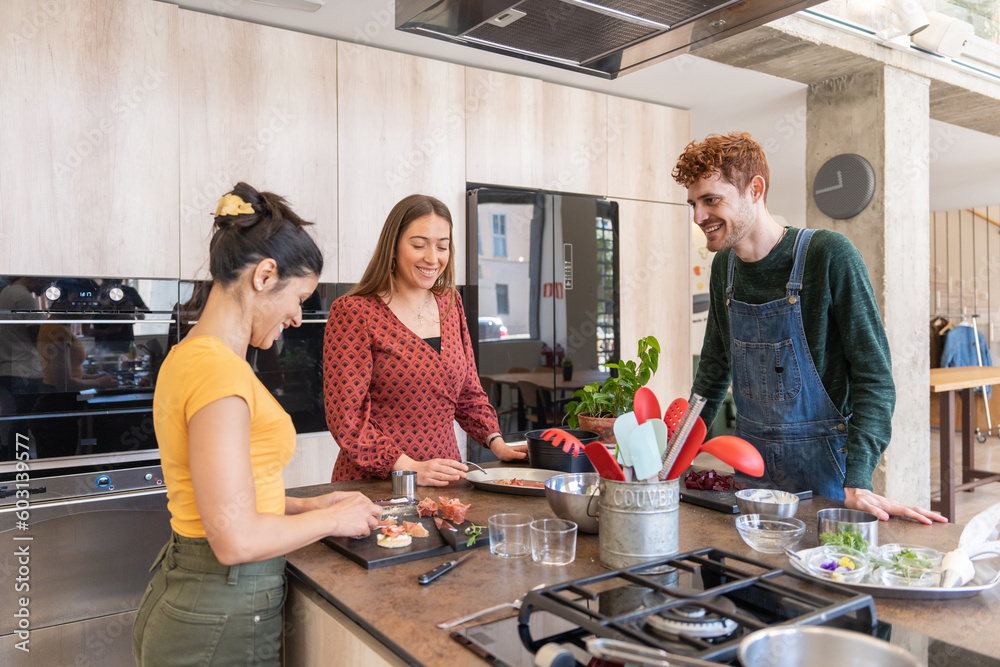 Three People Cooking Food Together In A Modern Kitchen. Three People Cooking Food Together In A Modern Kitchen.