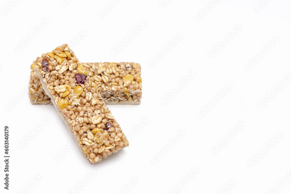 Two muesli bars on a white isolated background. Healthy sweet dessert snack. Cereal muesli with nuts, oatmeal and berries on a white background. Free space for text Two muesli bars on a white isolated background. Healthy sweet dessert snack. Cereal muesli with nuts, oatmeal and berries on a white background. Free space for text