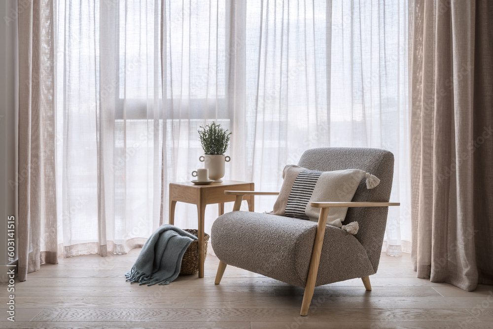 Grey armchair standing near coffee table with plaid in basket Grey armchair standing near coffee table with plaid in basket