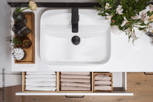 Fotografija storage fresh towels in wooden baskets in cabinet box in bathroom