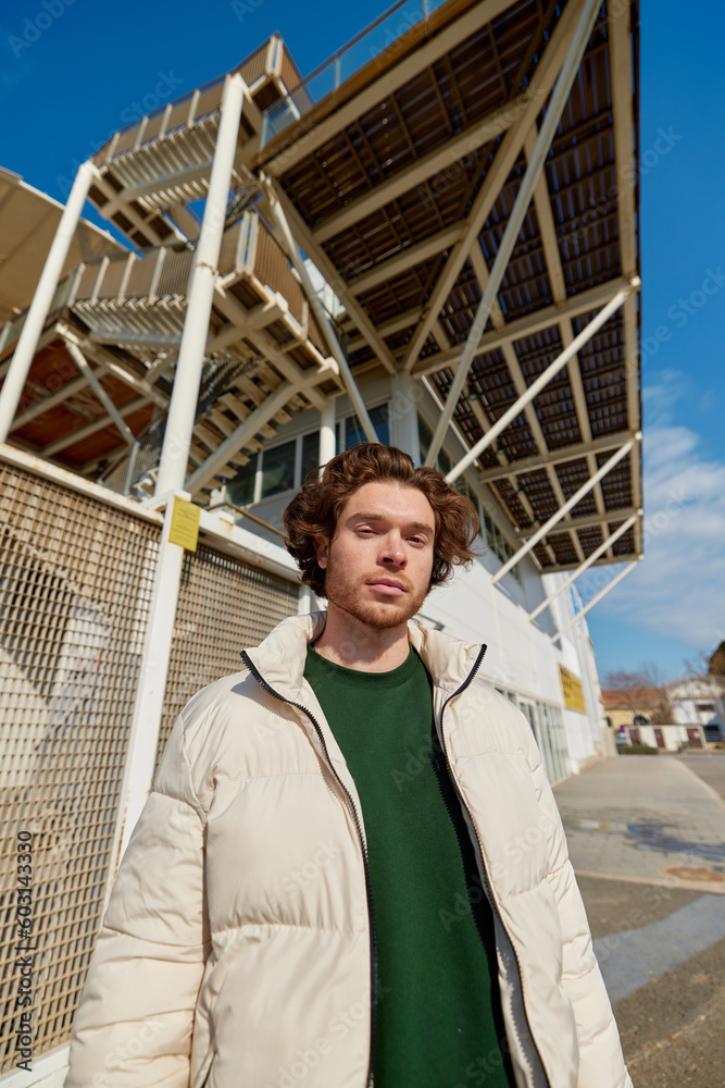 Confident young guy standing near building