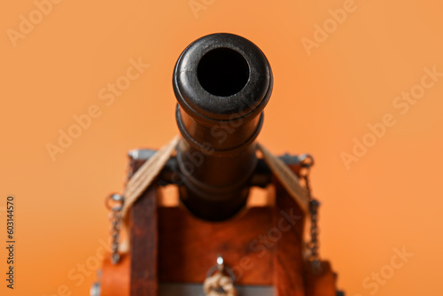 Konstfotografi Toy model of cannon on orange background, closeup