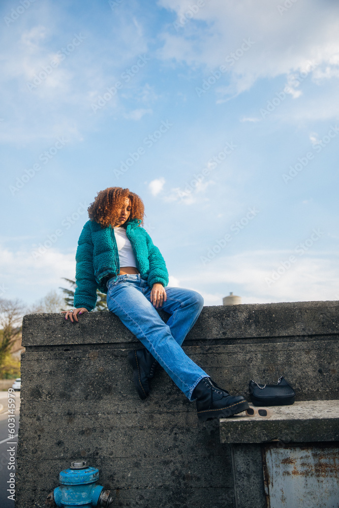 Woman sitting on top of a wall Woman sitting on top of a wall