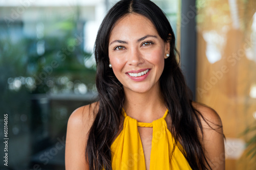 Smiling asian woman portrait wear yellow dress looking at camera