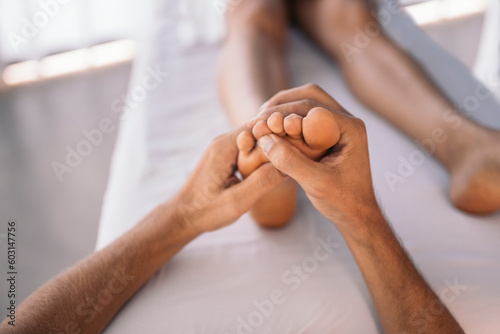 Hands of therapist treating a woman's feet photo