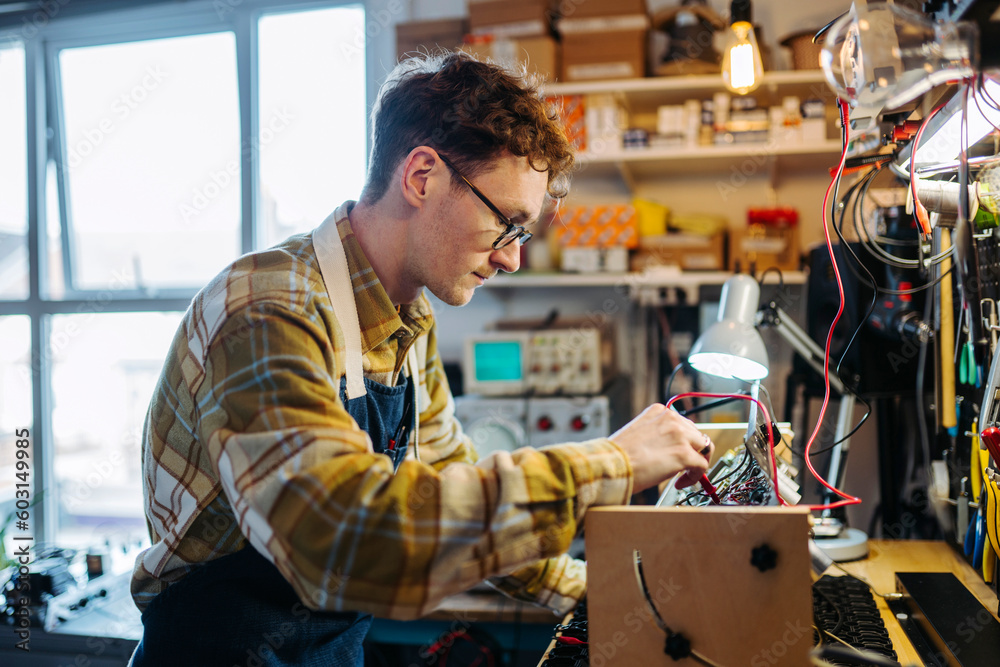Focused young man is working in repair workshop Focused young man is working in repair workshop