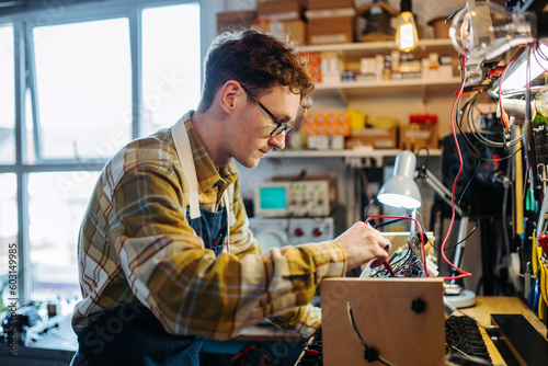 Focused young man is working in repair workshop photo