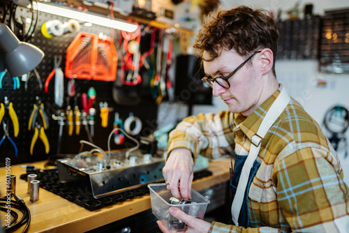 Repairman fixing amplifier in workshop photo