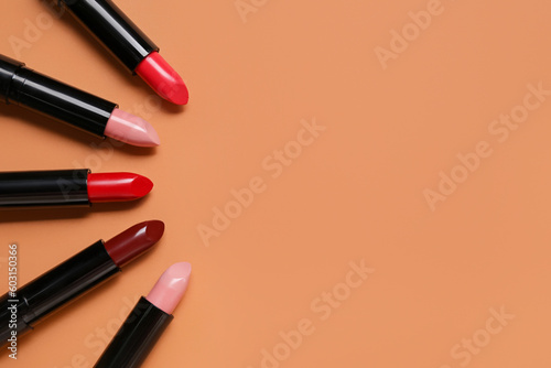 Frame made of different lipsticks on beige background