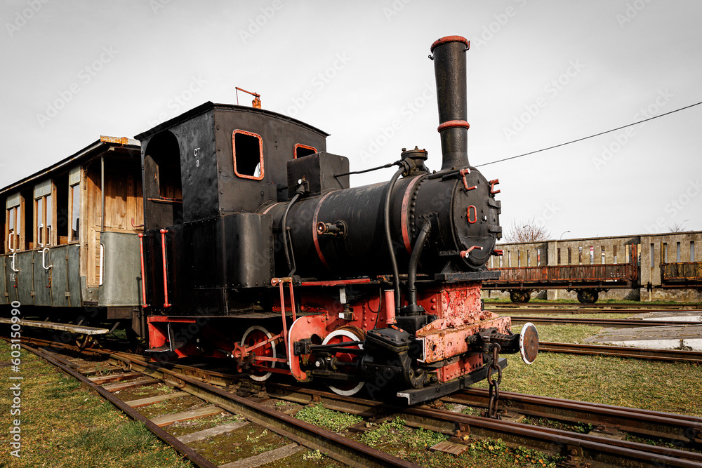 Naklejka premium Vintage locomotive, steam train in an outdoor depot.
