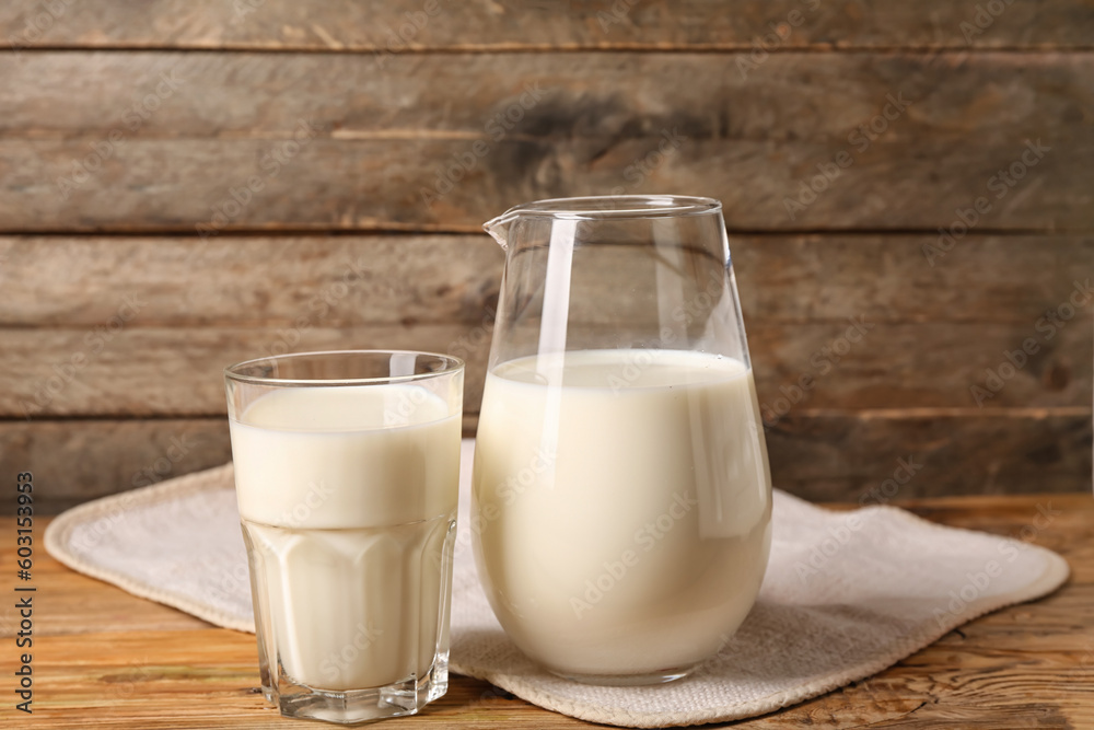 Jug and glass of fresh milk on wooden background Jug and glass of fresh milk on wooden background