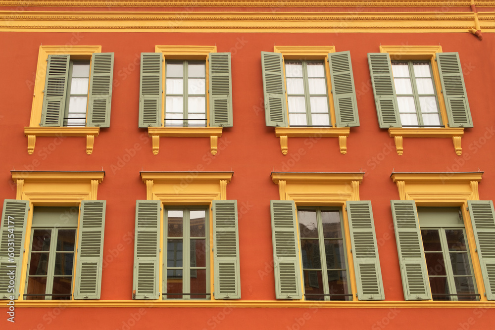 stylish orange building facade with green window shades stylish orange building facade with green window shades
