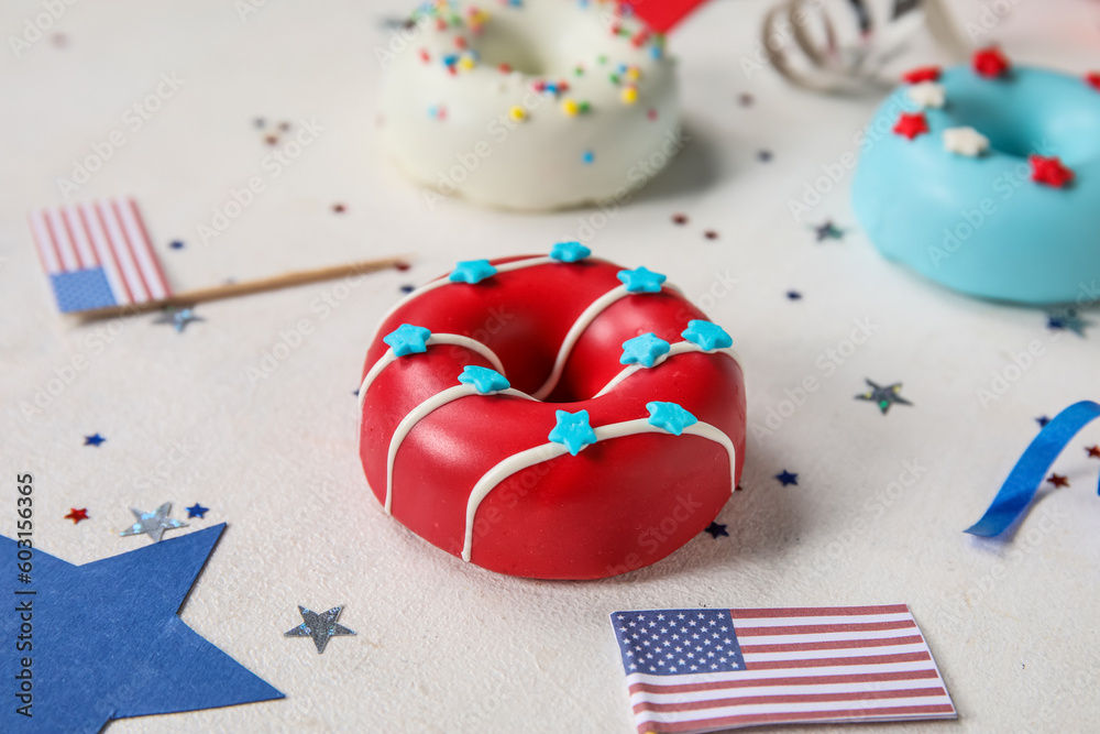 Composition with donuts, USA flags and confetti on white table, closeup. Independence Day celebration Composition with donuts, USA flags and confetti on white table, closeup. Independence Day celebration