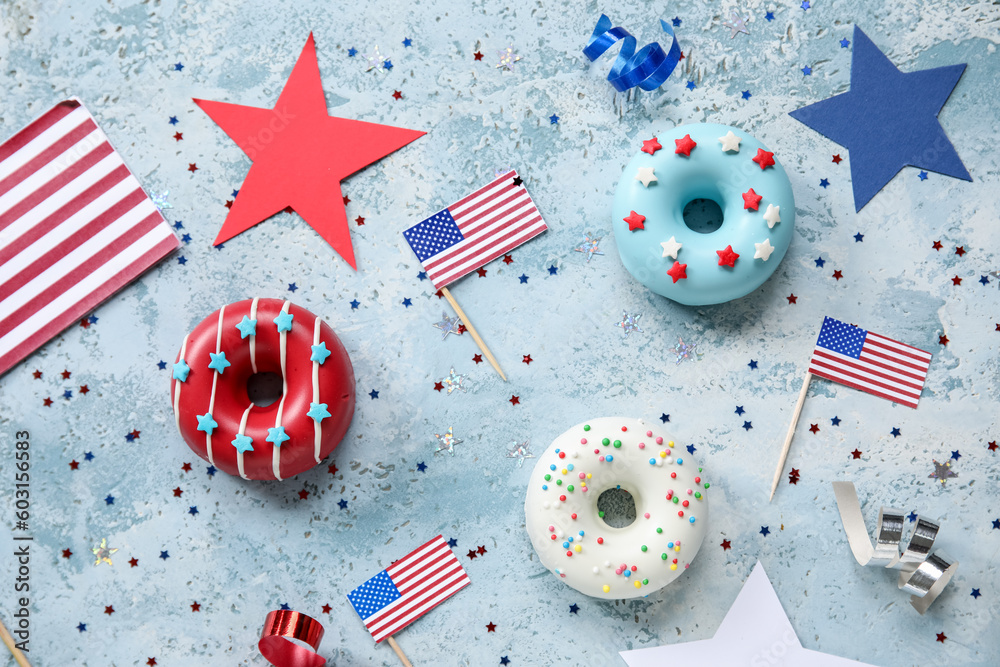 Obraz premium Composition with donuts, USA flags and confetti on blue grunge table. Independence Day celebration