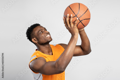Attractive Nigerian basketball player throwing ball isolated on white background