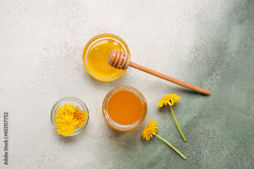 Jar and bowls with dandelion honey on white background