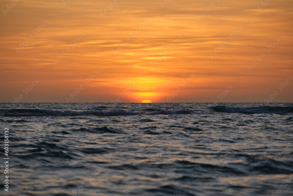 Obraz premium Ocean sunset. Big white sun on dramatic bright sky background, soft evening horizont over sea dark water